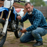 Homme d'âge moyen nettoyant la chaîne d'un dirt bike en extérieur