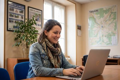 Jeune femme souriante utilisant un ordinateur dans un bureau Tarare