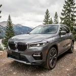 SUV moderne garé en altitude avec panorama montagneux en arrière-plan, vue trois-quarts avant