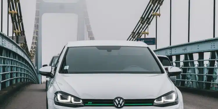 a white car driving across a bridge on a foggy day